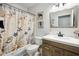 Well-lit bathroom featuring a single vanity, shower/tub combo, and coastal-themed decor at 5143 Lochmead Ter, Zephyrhills, FL 33541