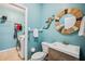 Charming bathroom with blue walls, a mermaid decoration, and adjacent laundry area at 5143 Lochmead Ter, Zephyrhills, FL 33541