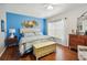 Bright bedroom featuring a comfortable bed, blue accent wall, and decorative art at 5143 Lochmead Ter, Zephyrhills, FL 33541