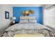 Inviting bedroom featuring a plush bed, vibrant accent wall, and decorative wall art at 5143 Lochmead Ter, Zephyrhills, FL 33541