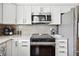 Beautiful kitchen with white cabinets, stainless steel appliances and sleek tile backsplash at 5143 Lochmead Ter, Zephyrhills, FL 33541