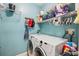 Functional laundry room with washer, dryer, wire shelves and storage space at 5143 Lochmead Ter, Zephyrhills, FL 33541