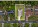 Aerial view showcasing the property and its position within a residential neighborhood with mature trees at 6043 Piedmont Dr, Spring Hill, FL 34606