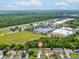 An aerial view of a home with a large grassy field and shopping center nearby at 6043 Piedmont Dr, Spring Hill, FL 34606