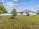 Backyard with grassy area, tree, patio, and white fence at 6043 Piedmont Dr, Spring Hill, FL 34606