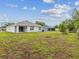 Expansive backyard showing the home's exterior, lush green lawn, and well-maintained landscaping at 6043 Piedmont Dr, Spring Hill, FL 34606