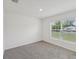 Bright, carpeted bedroom featuring a large window that provides ample natural light and pleasant views at 6043 Piedmont Dr, Spring Hill, FL 34606