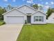 Attractive home with a well-maintained lawn, two-car garage, and inviting entrance at 6043 Piedmont Dr, Spring Hill, FL 34606