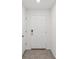 Secure white front door with modern hardware and tile flooring at 6043 Piedmont Dr, Spring Hill, FL 34606