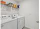 Bright laundry room with washer, dryer, and storage shelves for supplies at 6043 Piedmont Dr, Spring Hill, FL 34606