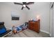 Cozy bedroom has a classic wood dresser, ceiling fan, and gray wood-look flooring at 670 42Nd Ne Ave, St Petersburg, FL 33703