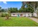 Charming single-story home with a well-manicured lawn, a bright blue front door, and mature trees at 670 42Nd Ne Ave, St Petersburg, FL 33703