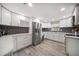Modern kitchen featuring white cabinets, stainless steel appliances, and stylish dark backsplash at 670 42Nd Ne Ave, St Petersburg, FL 33703