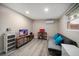 Cozy living room area with light wood floors, a futon sofa, and a mounted television at 670 42Nd Ne Ave, St Petersburg, FL 33703