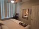 Bright bedroom featuring a window, ceiling fan, and a mirrored reflection of the bed at 701 Mirror Lake N Dr # 103, St Petersburg, FL 33701