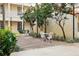 Charming outdoor courtyard with wrought iron furniture amidst manicured landscaping on brick pavers at 701 Mirror Lake N Dr # 103, St Petersburg, FL 33701
