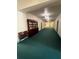 Long hallway with a blue-green carpet and a wooden bookcase with books in common area at 701 Mirror Lake N Dr # 103, St Petersburg, FL 33701