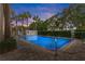 Inviting outdoor swimming pool area surrounded by lush greenery, palm trees and blue sky at dusk at 701 Mirror Lake N Dr # 103, St Petersburg, FL 33701