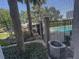 Screened view of community pool and landscaping with trees, view from patio at 701 Mirror Lake N Dr # 103, St Petersburg, FL 33701