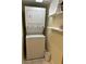 Compact laundry room with a stacked washer and dryer unit, and built-in shelving at 701 S Madison Ave # 410, Clearwater, FL 33756