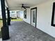 Outdoor patio with modern pavers, sleek ceiling fan, and crisp contrasting trim on the door and windows at 7021 Parliament Dr, Tampa, FL 33619