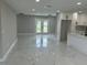 Large open living room featuring new tile floors and light fixtures, with great lighting from the new back doors at 7021 Parliament Dr, Tampa, FL 33619