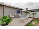 Backyard with wood deck featuring decorative patio furniture, landscaping, and view of home's exterior at 755 Green Valley Rd, Palm Harbor, FL 34683