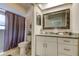 Bathroom featuring white vanity, framed mirror and shower with purple curtain at 755 Green Valley Rd, Palm Harbor, FL 34683