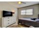 Bedroom with a comfortable bed, dresser, and modern ceiling fan at 755 Green Valley Rd, Palm Harbor, FL 34683