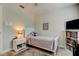 Bedroom featuring a cozy bed, nightstand, and a bookshelf with a TV at 755 Green Valley Rd, Palm Harbor, FL 34683