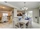 An open-concept dining room featuring a view of the kitchen, an elegant chandelier, and six chairs at 755 Green Valley Rd, Palm Harbor, FL 34683