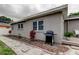Backyard exterior view of home with mulch beds, landscaping, grill and windows at 755 Green Valley Rd, Palm Harbor, FL 34683