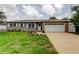 Charming single-story home with a well-maintained lawn, tidy landscaping, and a white two car garage door at 755 Green Valley Rd, Palm Harbor, FL 34683
