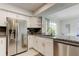 Contemporary kitchen with stainless steel appliances, granite countertops, white cabinets, and an adjacent dining area at 755 Green Valley Rd, Palm Harbor, FL 34683