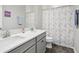 Well-lit bathroom with double vanity, granite countertop and decorative shower curtain at 808 Vittorio Pl, Brandon, FL 33511