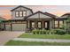 Inviting home featuring manicured landscaping, covered porch with seating, and a three-car garage at 808 Vittorio Pl, Brandon, FL 33511