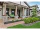 Covered front porch with green furniture, stone columns, brick pavers and beautiful landscaping at 808 Vittorio Pl, Brandon, FL 33511