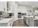 Bright kitchen featuring white cabinetry, stainless steel appliances, a tile backsplash, and wood-look tile flooring at 808 Vittorio Pl, Brandon, FL 33511