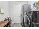 Modern laundry room featuring gray, stacked washer and dryer units with a nearby door at 808 Vittorio Pl, Brandon, FL 33511