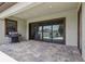An outdoor living area with stone pavers, a grill and sliding glass doors leading indoors at 808 Vittorio Pl, Brandon, FL 33511