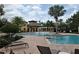 Resort-style pool area with a clubhouse, palm trees, lounge chairs, and lush landscaping at 808 Vittorio Pl, Brandon, FL 33511