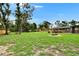 Expansive grassy yard with mature trees, a patio, and a partially screened pool area for relaxing outdoor enjoyment at 8222 Valrie Ln, Riverview, FL 33569