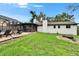 A view of the grassy backyard with brick-paved patio, screened pool, and attached house at 8222 Valrie Ln, Riverview, FL 33569
