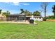 The grassy backyard contains a screened pool, lounge chairs, and a black barbeque for outdoor fun at 8222 Valrie Ln, Riverview, FL 33569