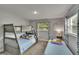 Cozy bedroom featuring bunk beds and a comfortable twin bed with natural lighting at 8222 Valrie Ln, Riverview, FL 33569