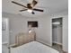 Bedroom with a ceiling fan, TV, dresser, closet, and ensuite bathroom at 8222 Valrie Ln, Riverview, FL 33569
