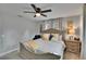 A well-lit bedroom with a ceiling fan, two windows, gray curtains, and a queen-sized bed with decorative pillows at 8222 Valrie Ln, Riverview, FL 33569