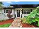 Close-up of front entrance with a brick walkway, lush tropical plants, and an ornate front door at 8222 Valrie Ln, Riverview, FL 33569