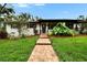 Inviting front entrance with a brick walkway, lush plants, and a decorative front door at 8222 Valrie Ln, Riverview, FL 33569