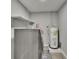 Well-lit laundry room featuring a washer, dryer, water heater, and storage shelves at 8222 Valrie Ln, Riverview, FL 33569
